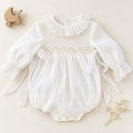 Pagliaccetto battesimo bimba avorio con punto smock, ricami beige e volant