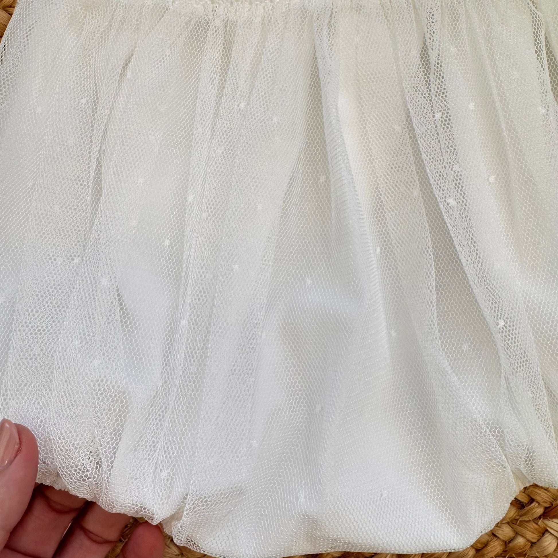 dettaglio pagliaccetto battesimo bimba con pizzo e lavorazione smock