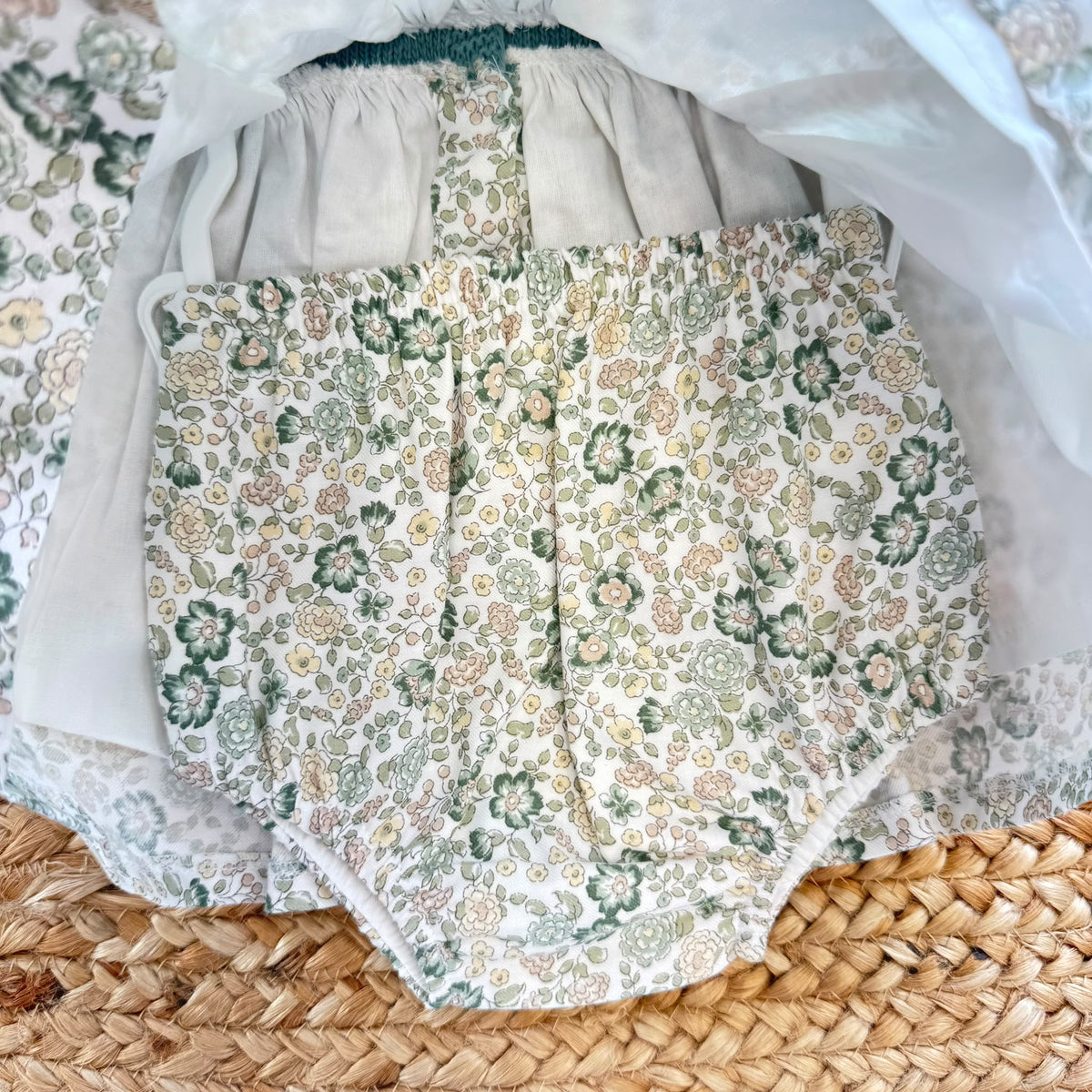 Abito pagliaccetto bimba verde Sardon con fantasia floreale e pompon