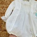 Pagliaccetto battesimo bimba bianco con punto smock, pizzo floreale e tulle, vista frontale