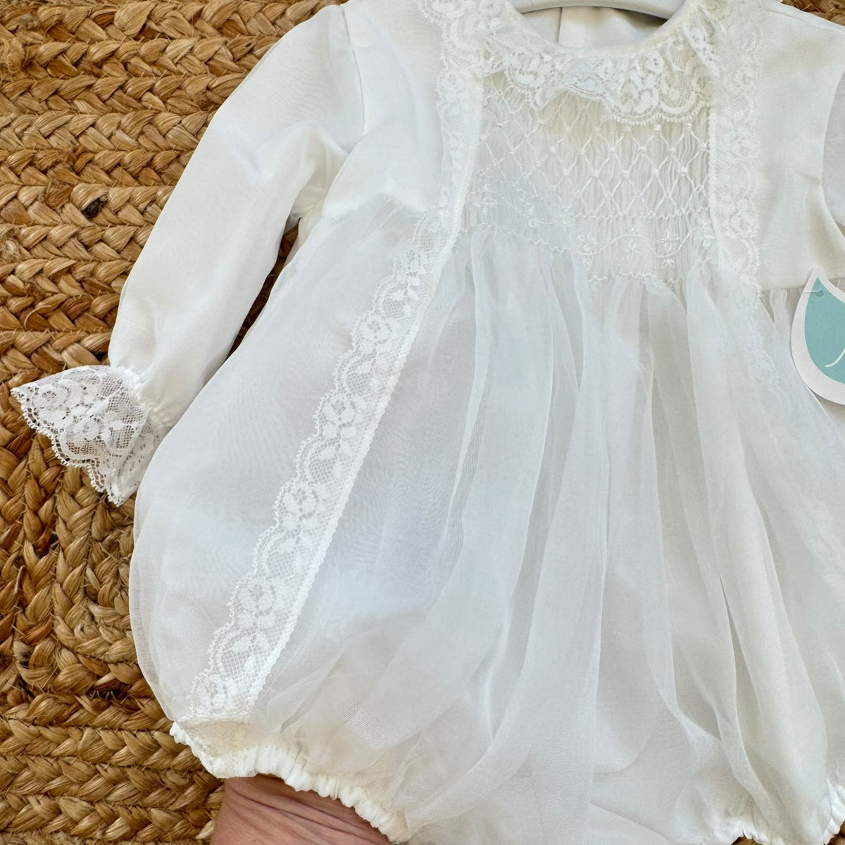 Pagliaccetto battesimo bimba bianco con punto smock, pizzo floreale e tulle, vista frontale