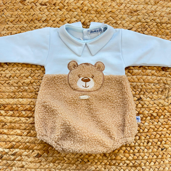 Dettaglio del tessuto teddy e dei bottoni del pagliaccetto neonato azzurro in caldo cotone.