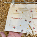 Completo bimba con maglioncino rosa a trecce e pantaloncini panna a coste con ricami floreali.
