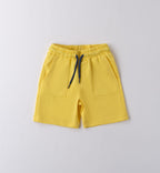 T-shirt bianca con stampa tropicale e pantaloncini gialli per bambino, abbigliamento estivo vivace.