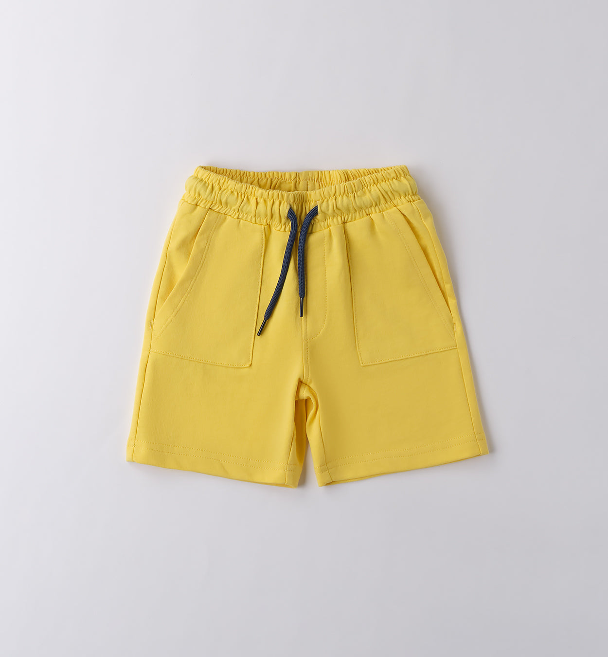 T-shirt bianca con stampa tropicale e pantaloncini gialli per bambino, abbigliamento estivo vivace.