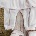 Dettaglio pantalone rosa in ciniglia con profili floreali coordinati
