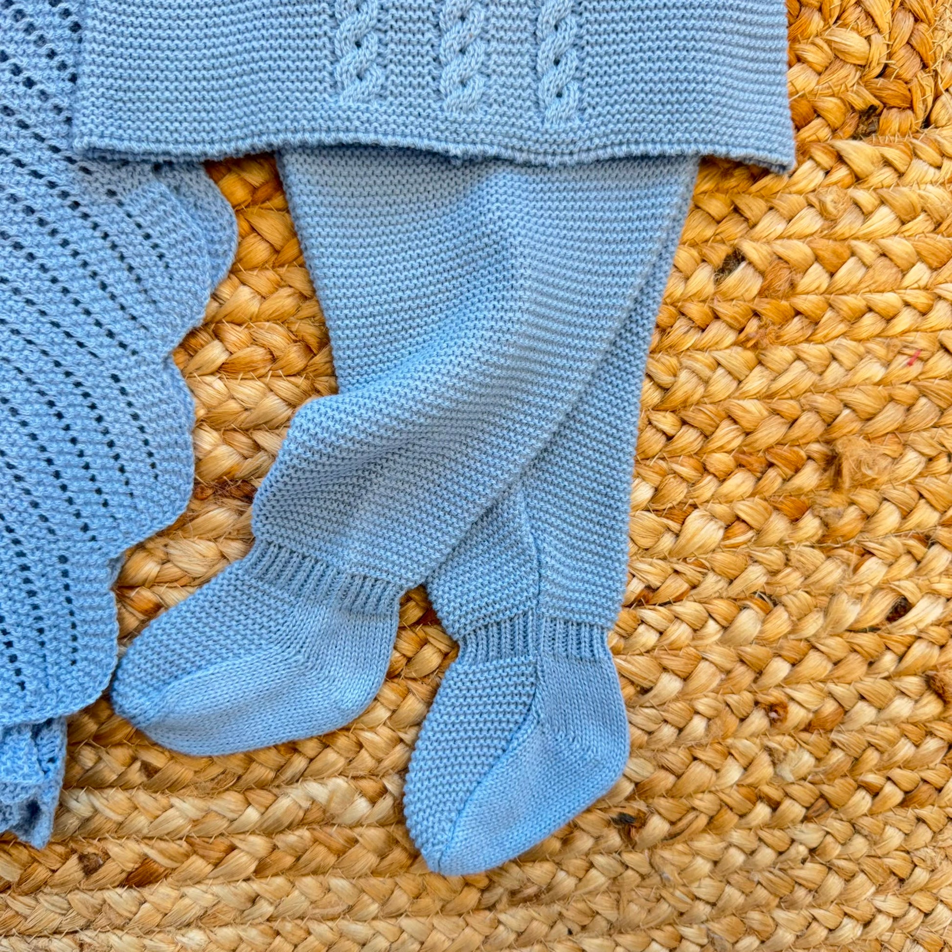 Set nascita neonato azzurro con copertina, maglioncino con trecce, pantalone con piedini e cappellino con pompon