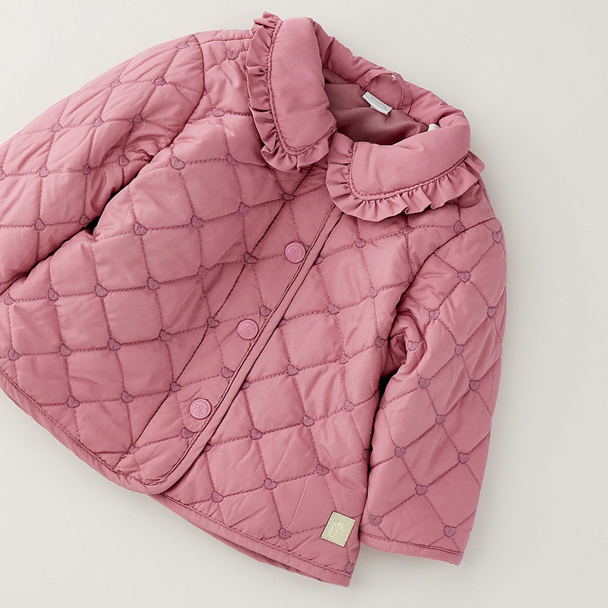Piumino bimba rosa trapuntato con colletto volant e cuori tono su tono
