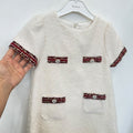 Dettaglio abito elegante bambina panna bouclé con passamaneria bordeaux e decorazioni di perline