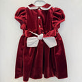 Abito bimba in velluto bordeaux con punto smock, colletto bianco a contrasto e maniche a palloncino.