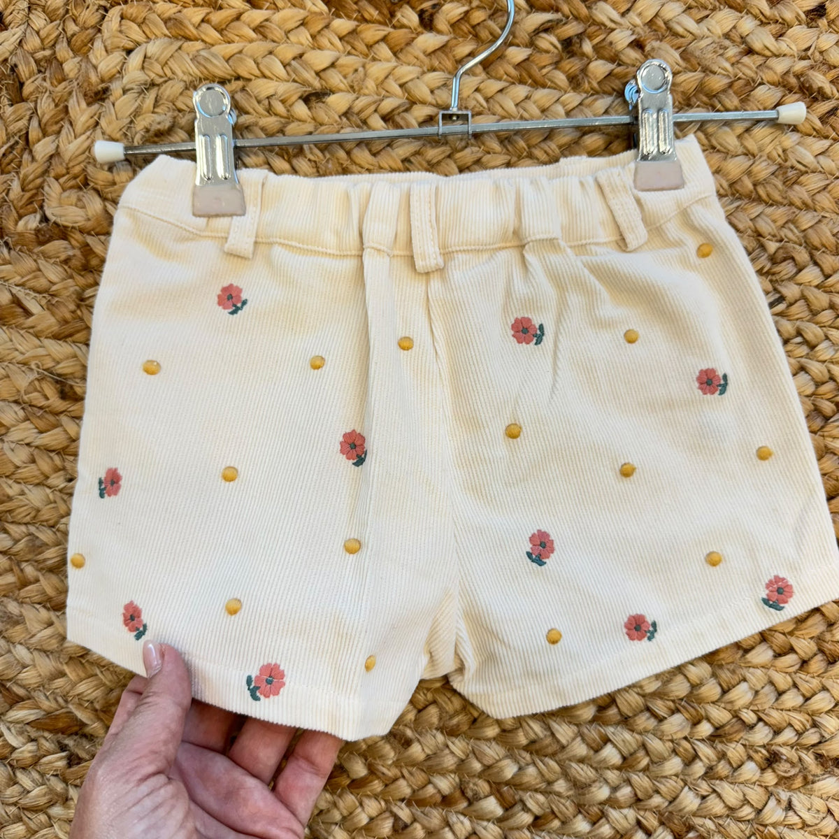 Completo bimba con maglioncino rosa a trecce e pantaloncini panna a coste con ricami floreali.
