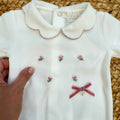 Tutina neonata in ciniglia panna con ricami floreali e fiocco rosa Made in Italy.