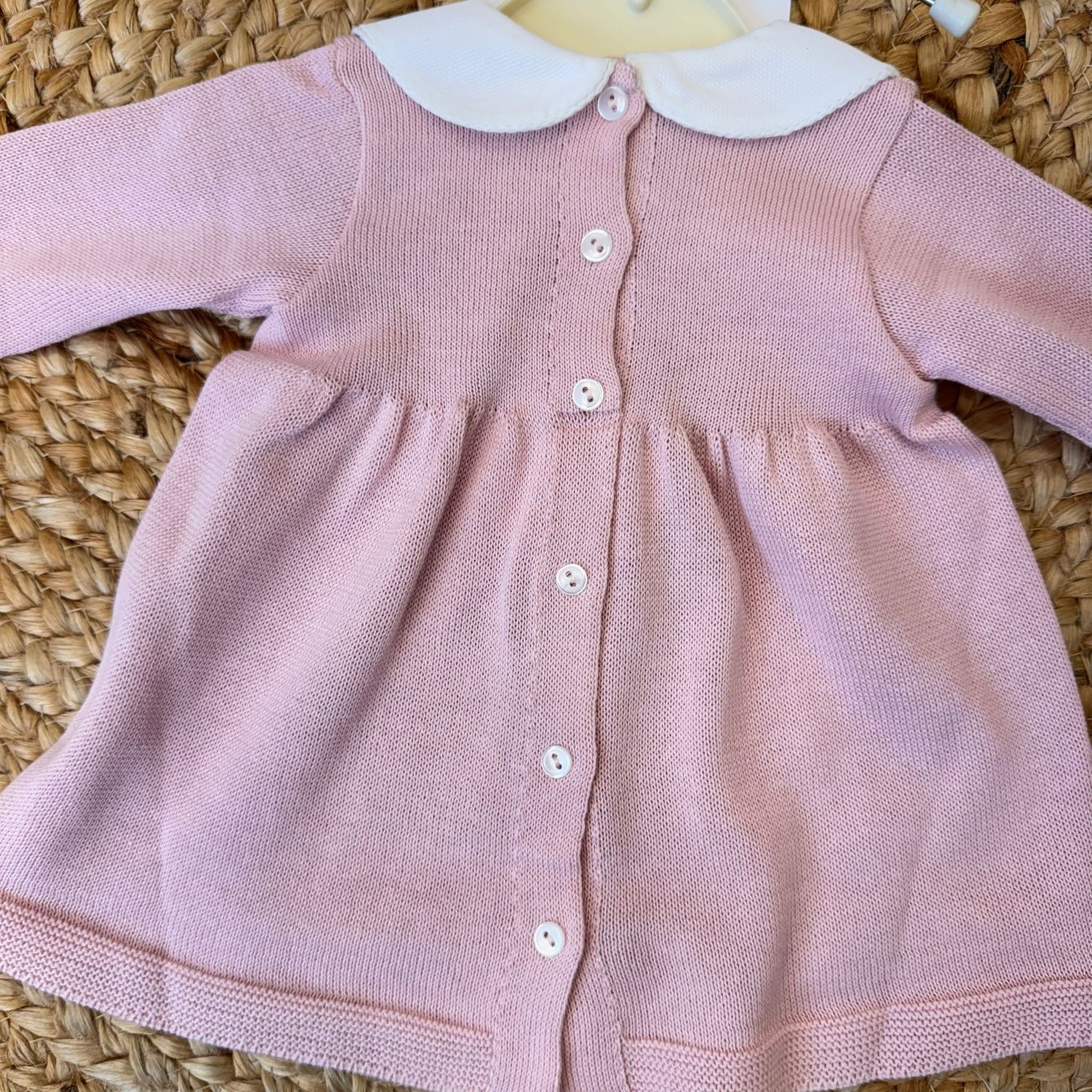 Retro della tutina neonata rosa con chiusura a bottoni