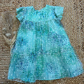 Vestito bambina verde salvia con fiori stampati, volant e fiocco blu

