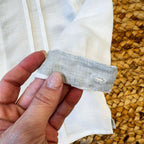 Primo piano del risvolto del pantalone in lino verde salvia