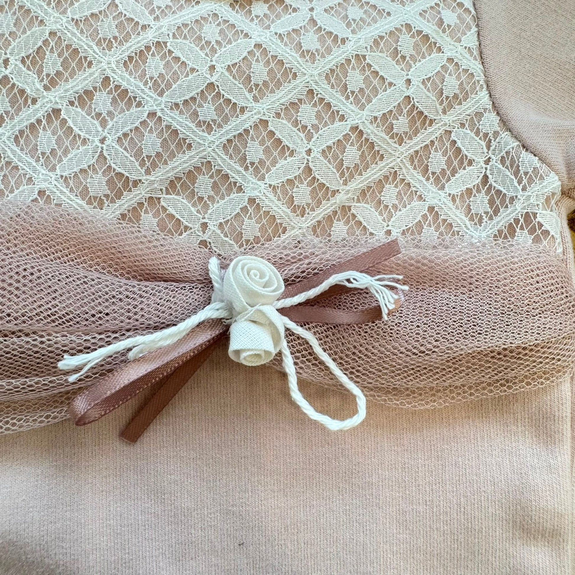 Tutina in caldo cotone rosa neonata con pizzo, tulle, rosellina decorativa e colletto arrotondato.