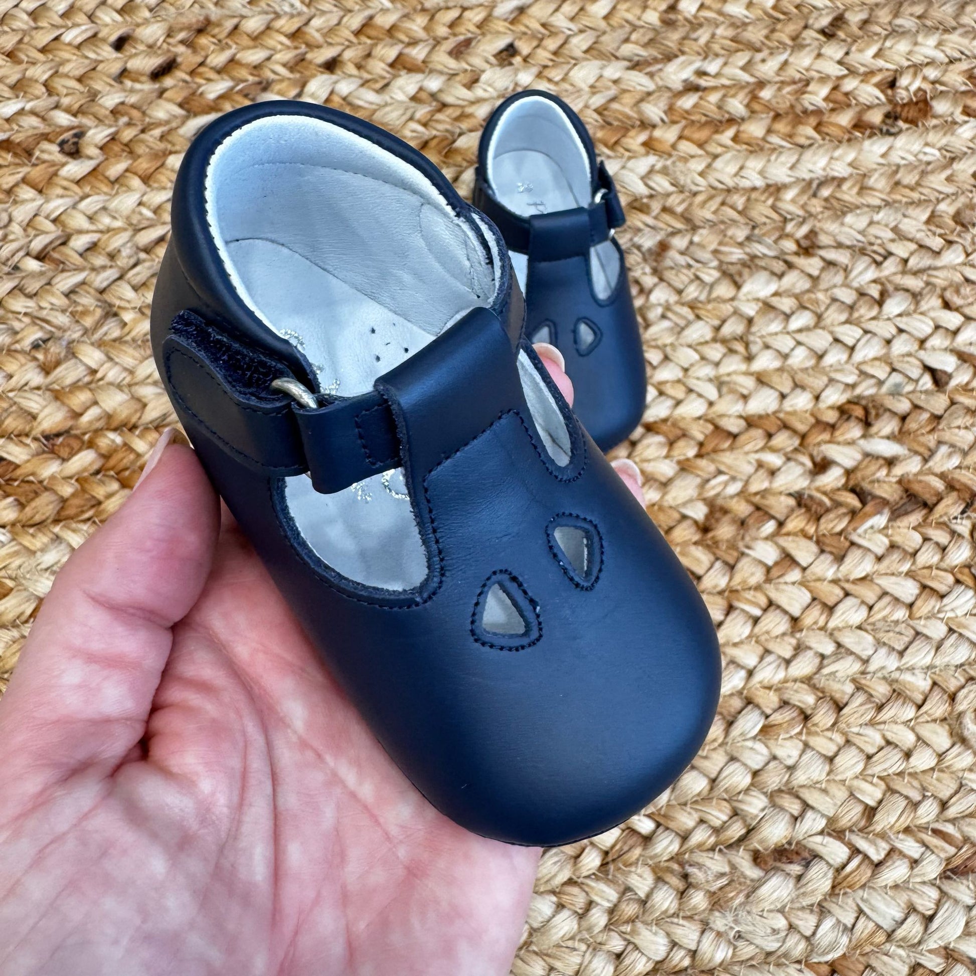 Scarpa culla in pelle blu con cinturino regolabile e fori decorativi