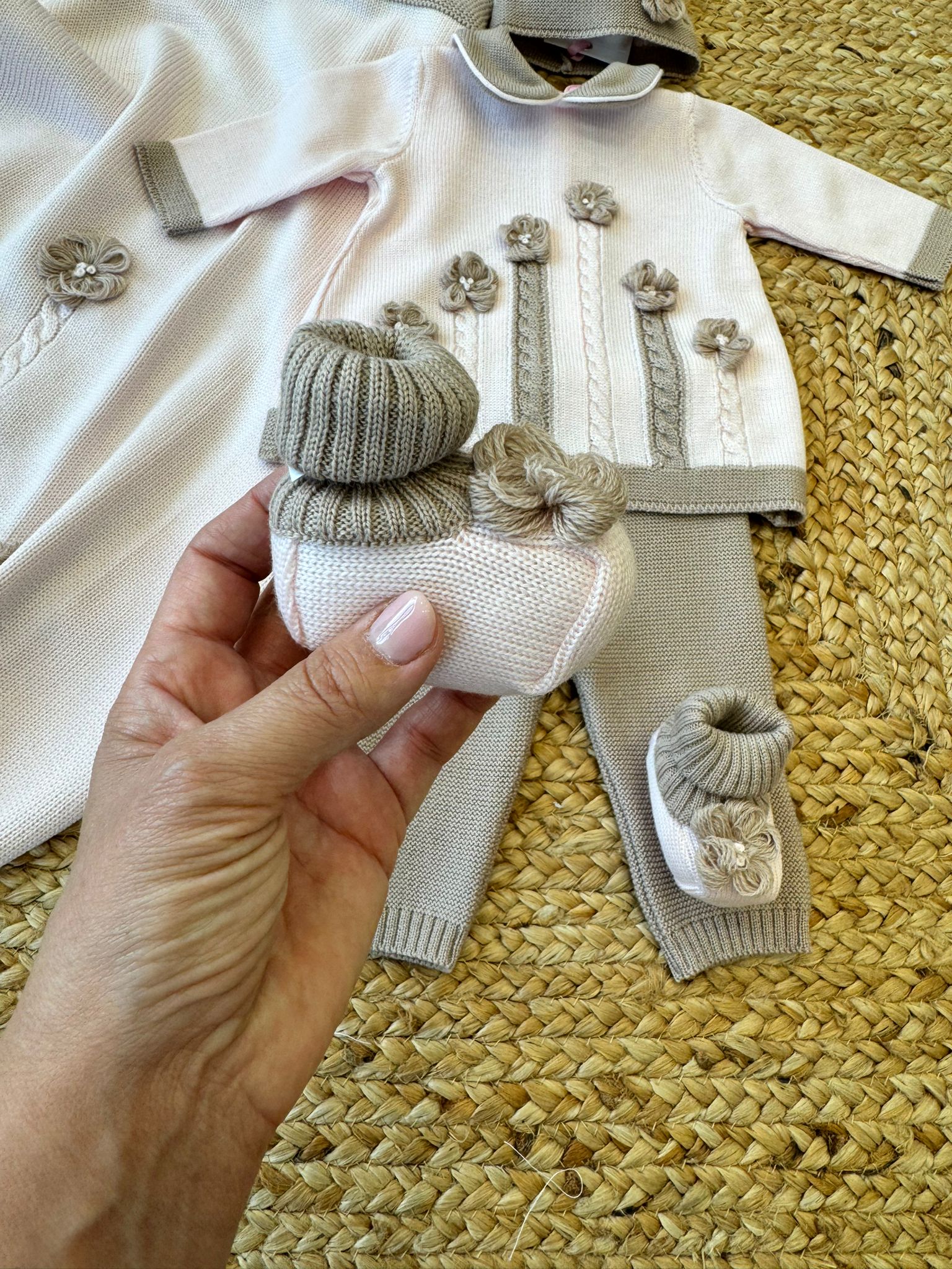 Cappellino neonata in lana rosa con bordo beige e lavorazione a maglia
