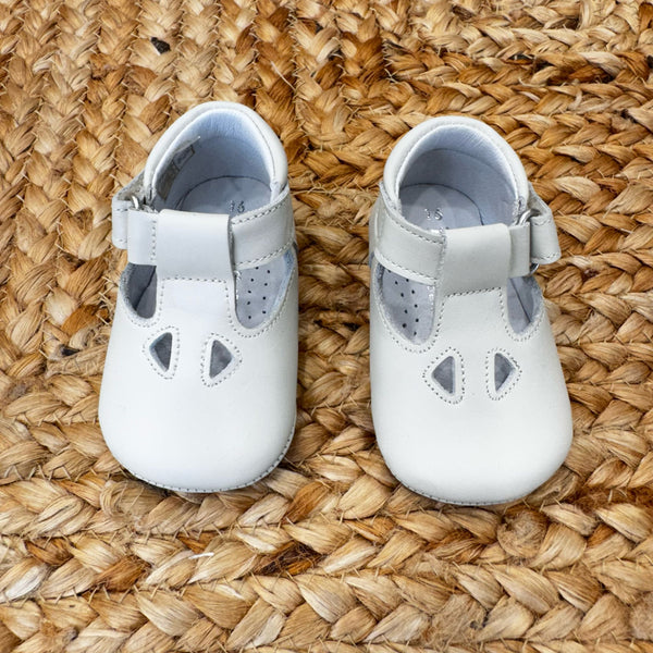 Scarpa culla in pelle bianca con cinturino regolabile e fori decorativi