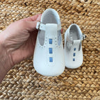 Scarpa culla bianca in pelle con dettagli blu e cinturino regolabile