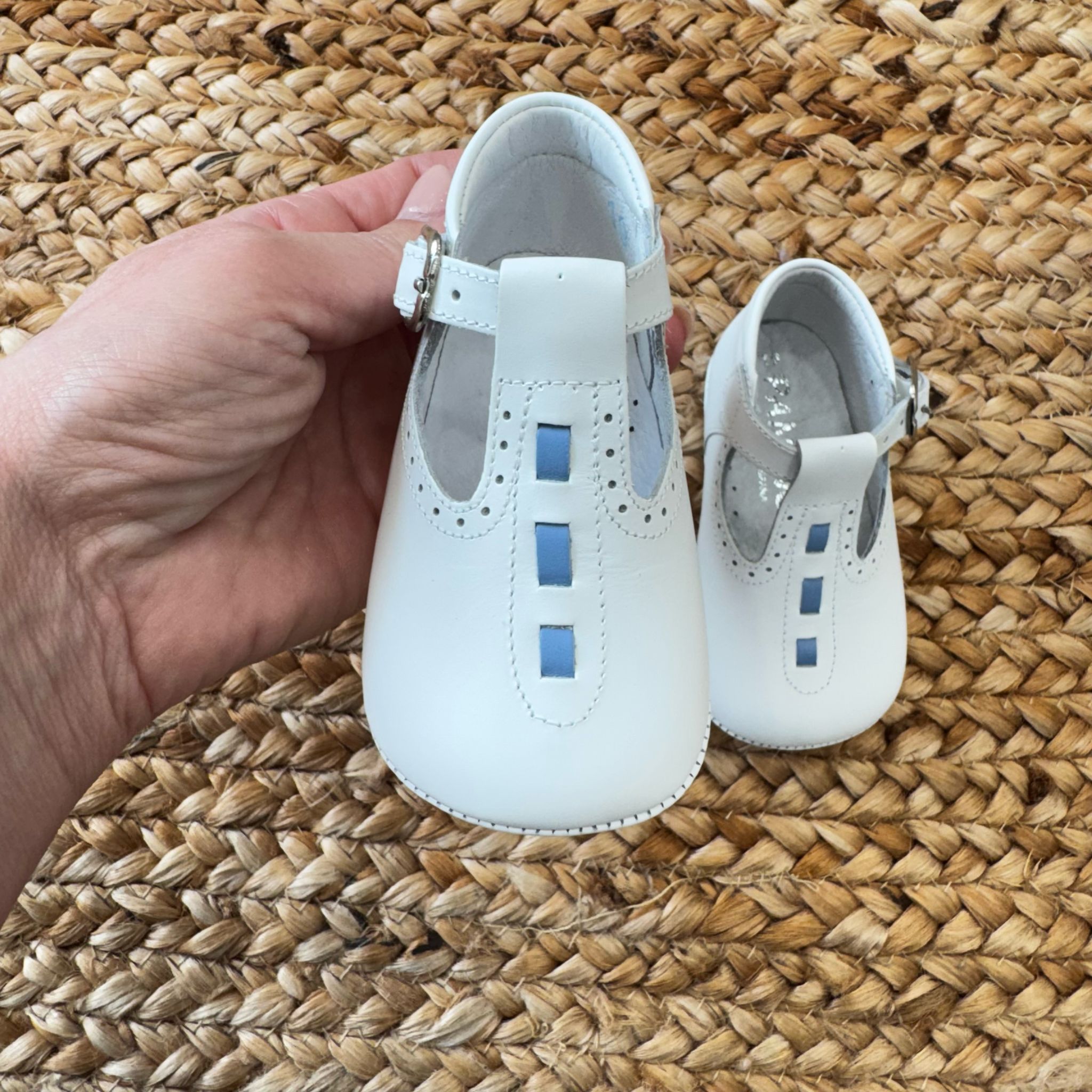 Scarpa culla bianca in pelle con dettagli blu e cinturino regolabile