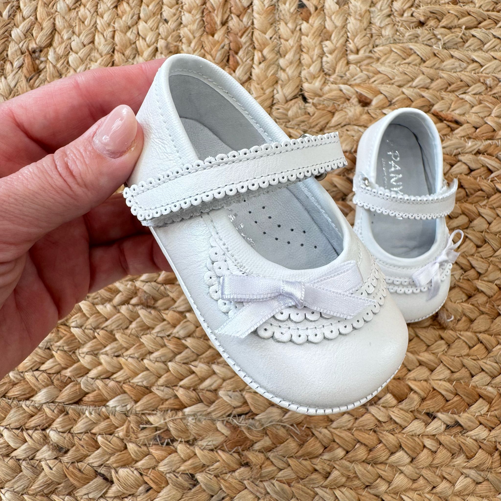 Scarpa culla bianca traforata con fiocco – Eleganza e raffinatezza