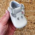 Scarpa culla in pelle bianca con cinturino regolabile e fori decorativi