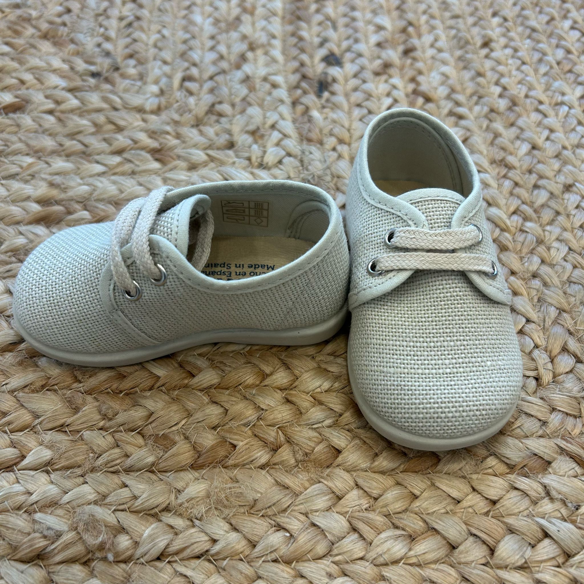 Scarpe eleganti da neonato in tessuto beige con lacci, ideali per cerimonia o primo compleanno

