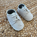 Dettaglio scarpa elegante bimbo beige con lacci, cuciture e lavorazione traforata
