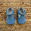 Scarpe battesimo bimbo azzurro con cinturino e dettagli decorativi frontali.