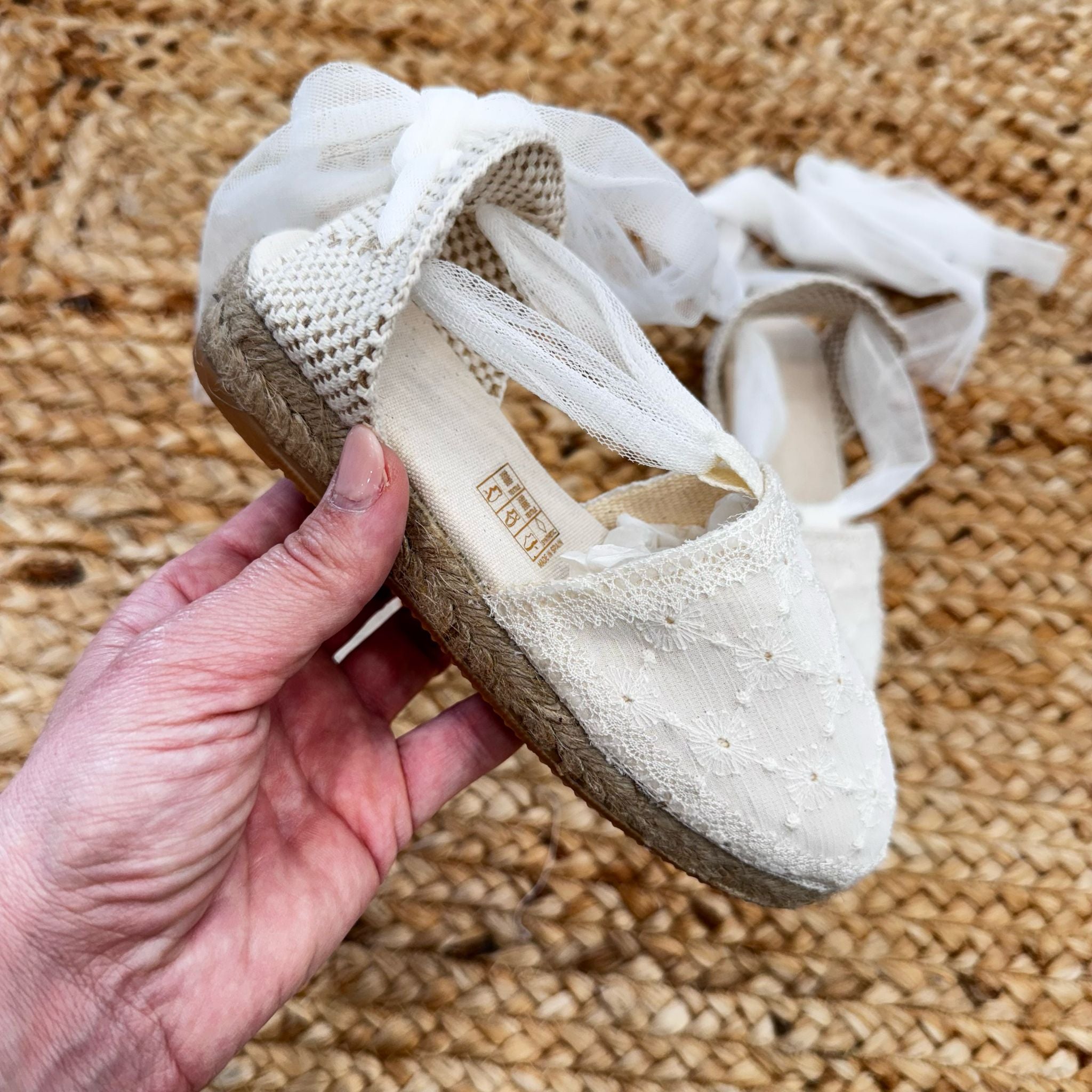 Scarpe culla eleganti in pizzo con suola in corda, ideali per cerimonie e battesimi.