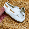 Scarpe culla modello barchetta in pelle bianca con cuciture a contrasto e chiusura a lacci, ideali per neonati in occasioni speciali.

