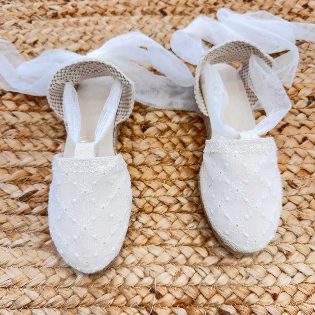 Scarpe culla eleganti in pizzo con suola in corda, ideali per cerimonie e battesimi.