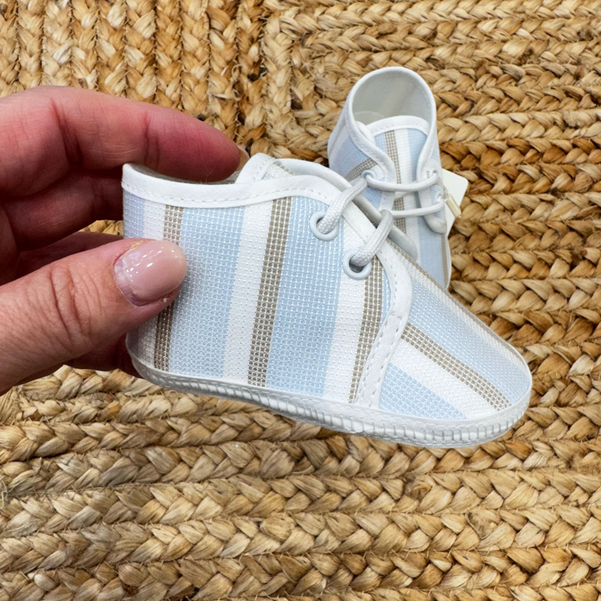 Scarpe culla in tessuto a righe azzurre e beige con chiusura a lacci, ideali per neonati in primavera ed estate.