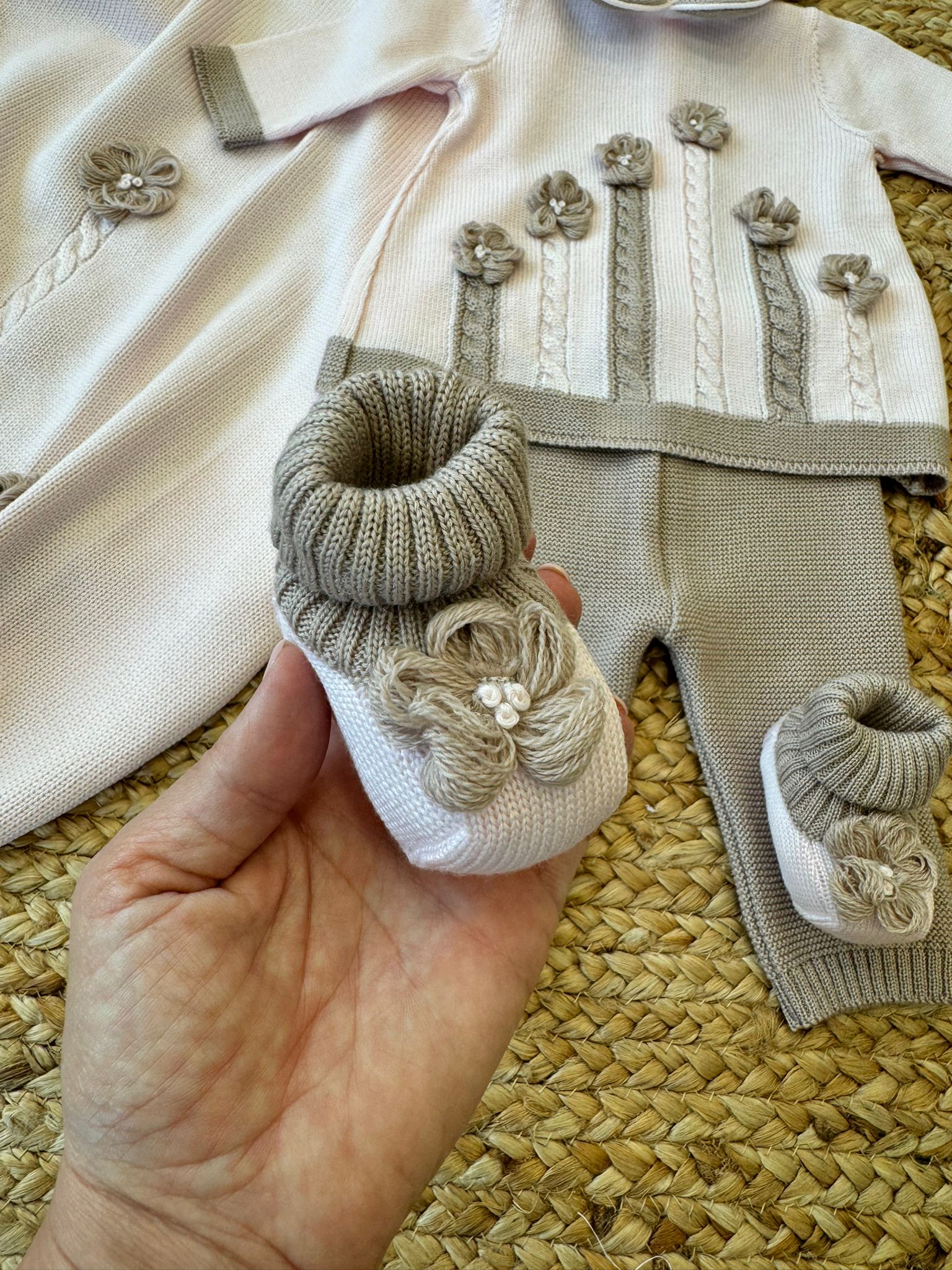 Cappellino neonata in lana rosa con bordo beige e lavorazione a maglia