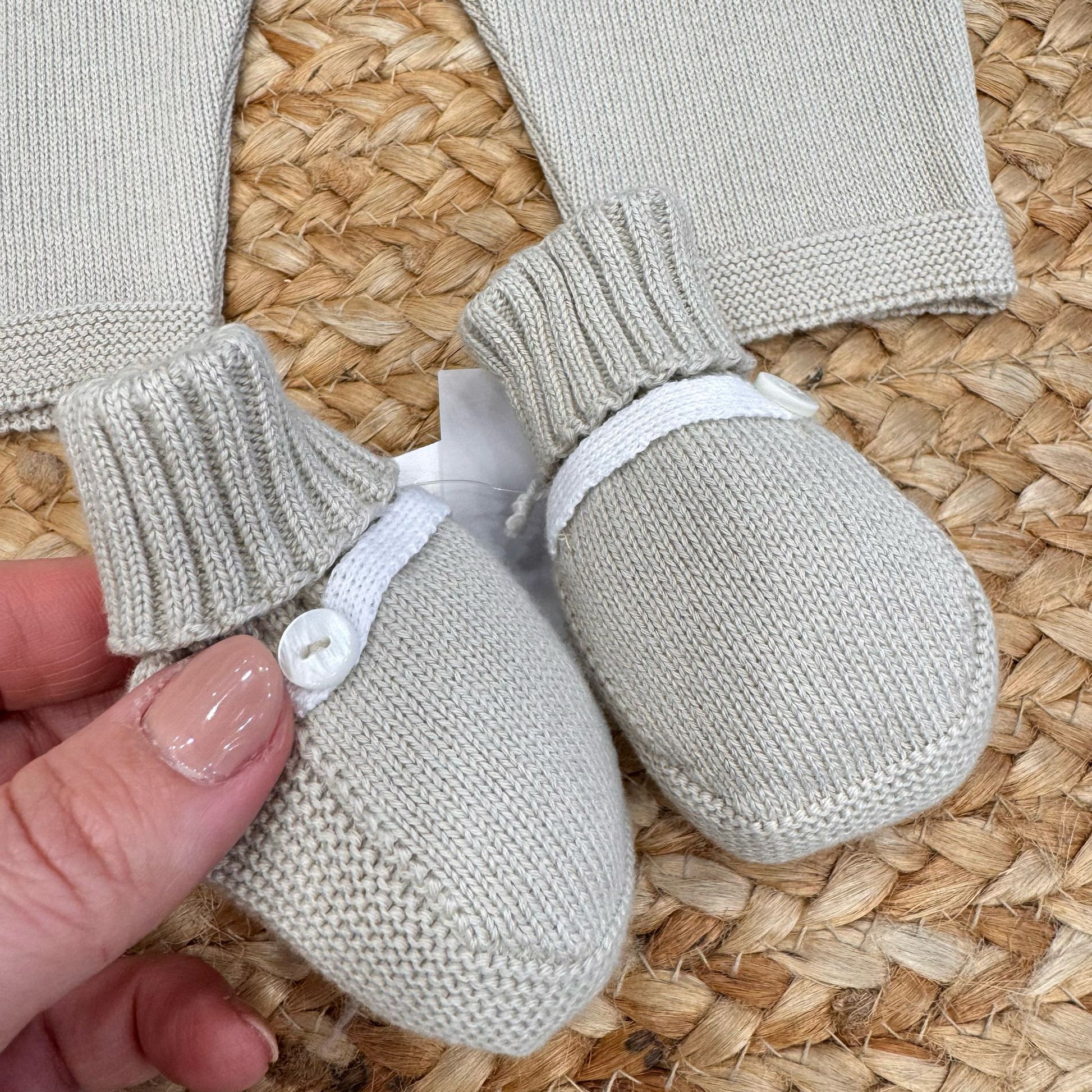 Scarpette neonato in maglia beige con bottoncino bianco