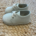 Scarpe eleganti da neonato in tessuto beige con lacci, ideali per cerimonia o primo compleanno

