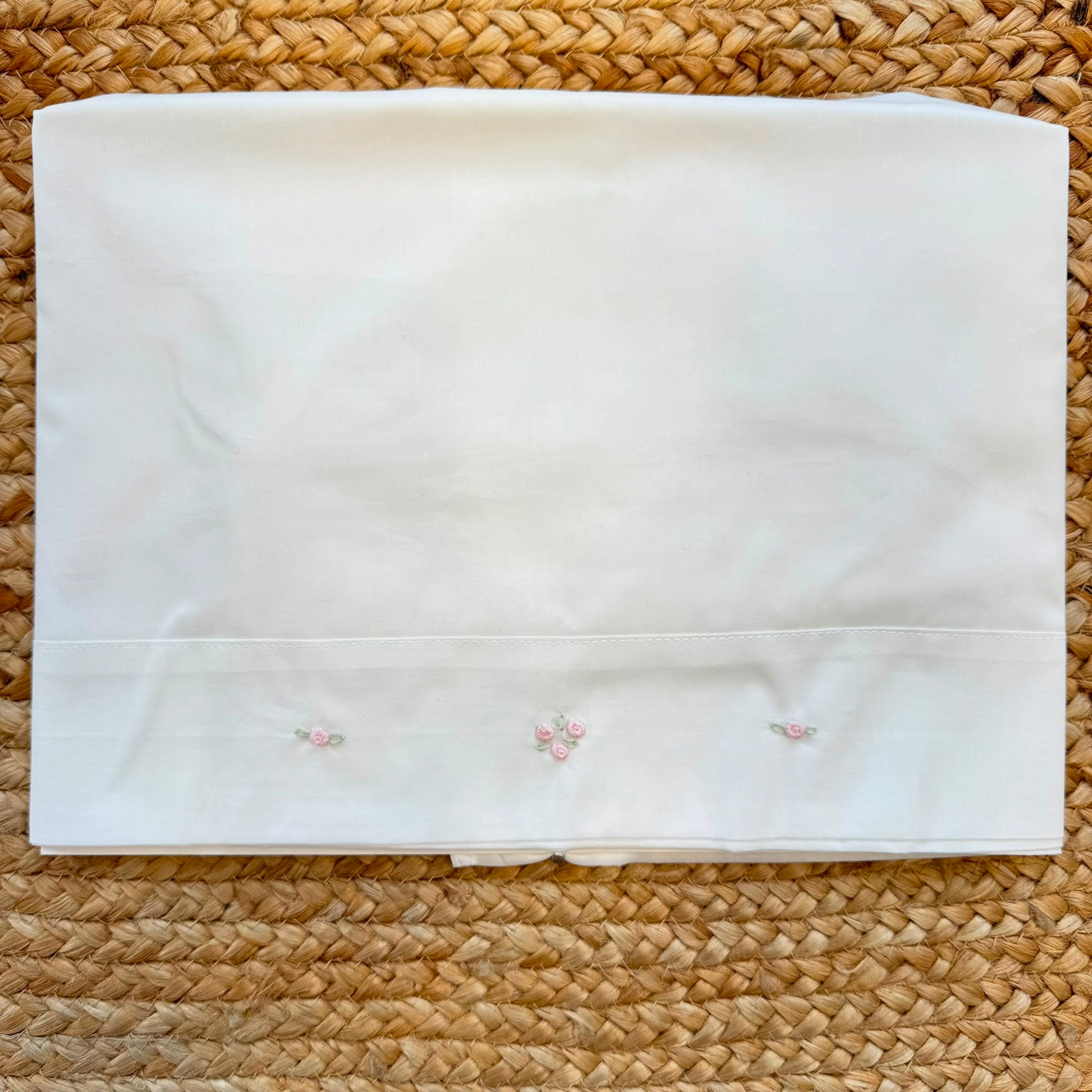 Set lenzuola culla e carrozzina in cotone colore latte con federa ricamata a fiori rosa per neonata.