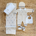 Tutina neonato beige in lana e cotone con dettagli blu e bavetta bianca con orsetto ricamato