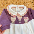 Uscita clinica neonata in ciniglia bianco panna e prugna con tutina, copertina sfoderabile, bavetta, cappellino, scarpine e lenzuolino coordinati.