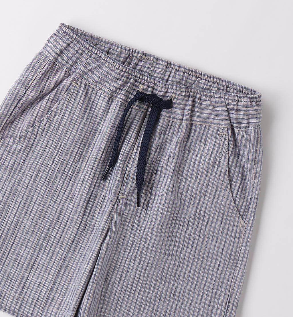 Completo bambino con t-shirt bianca "Enjoy the Ride" e shorts a righe blu.