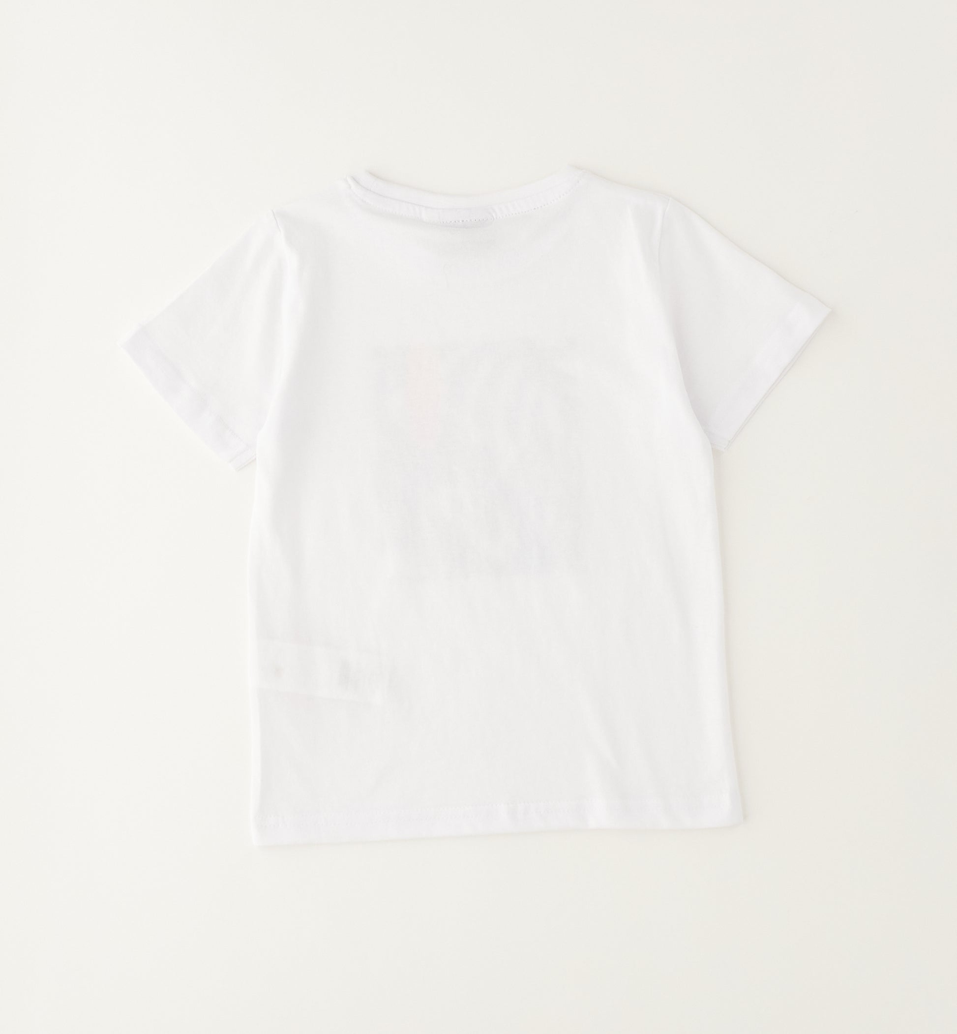 Dettaglio t-shirt bimbo in cotone con stampa tropicale e surf
