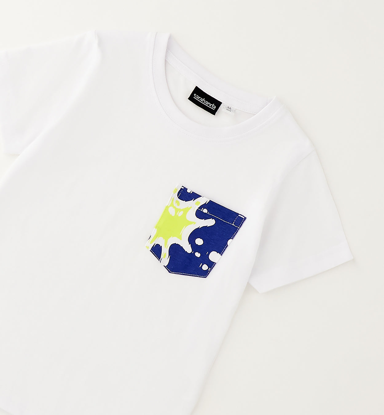 Dettaglio t-shirt bimbo in cotone con taschino fantasia mare nei toni blu e giallo
