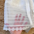 Dettaglio del bordo in tulle con ricamo floreale.