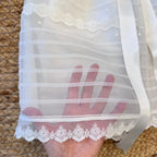 Dettaglio del bordo in tulle con ricamo floreale.