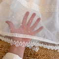 Voile trasparente con pois ricamati sull’abito battesimo

