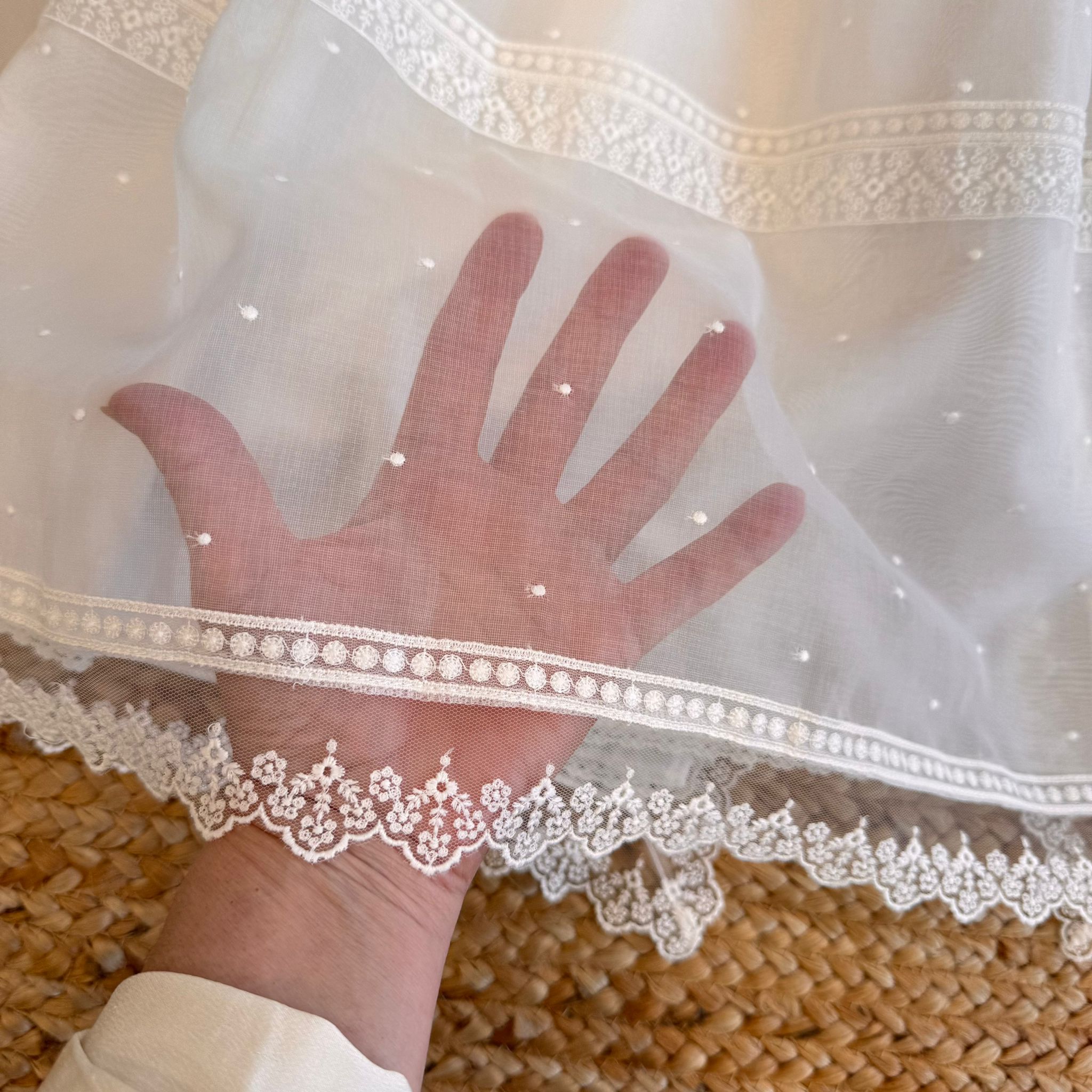 Voile trasparente con pois ricamati sull’abito battesimo

