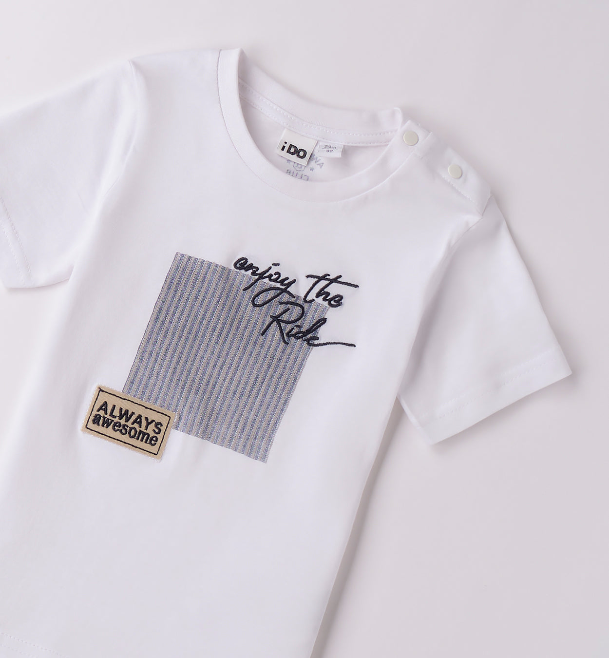 Completo bambino con t-shirt bianca "Enjoy the Ride" e shorts a righe blu.