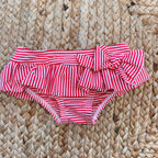 Costume slip a righe rosse con fiocco e t-shirt con stampa barchetta per bambina.

