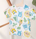 T-shirt bimbo con stampa colorata di animali della savana su fondo bianco.

